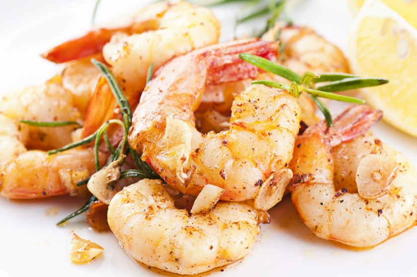 fried king fried king prawns with garlic and herbs as closeup on a white plate