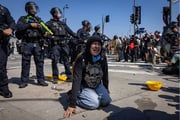 Manifestante chora ajoelhada no chão após confronto com a polícia no centro de Los Angeles, perto do Prédio Federal e do Centro de Detenção Metropolitano, devido às operações de imigração que assolam Los Angeles 