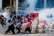 Policiais de Los Angeles disparam gás lacrimogêneo enquanto avançam sobre manifestantes que formaram uma barricada improvisada no centro da cidade durante um protesto contra batidas de imigração em 8 de junho de 2025 em Los Angeles, Califórnia