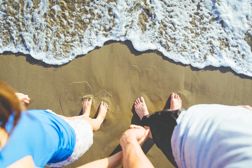 Couple holding each others hands in front of the ocean