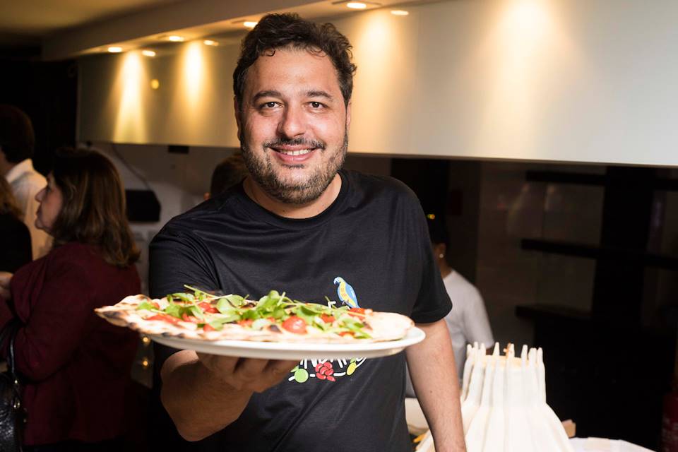 Chef Gil Guimarães segurando uma pizza