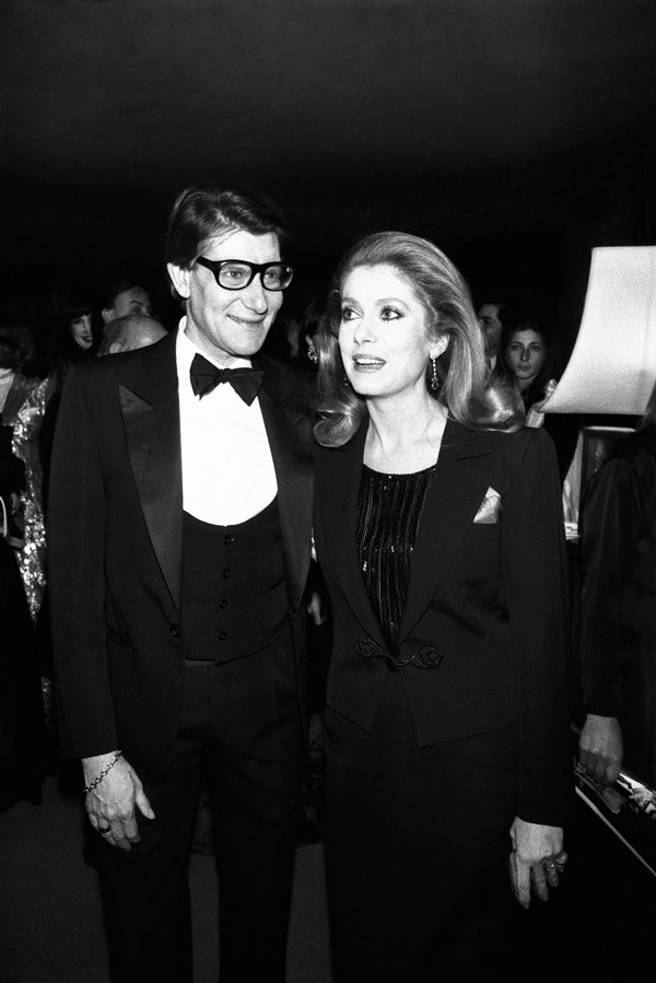 Na imagem em preto e branco, o estilista Yves Saint Laurent ao lado da atriz catherine deneuve 