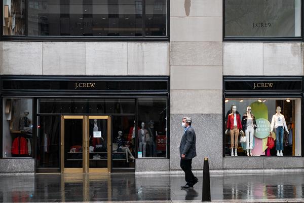 Homem com máscara passando em frente a loja da J.Crew