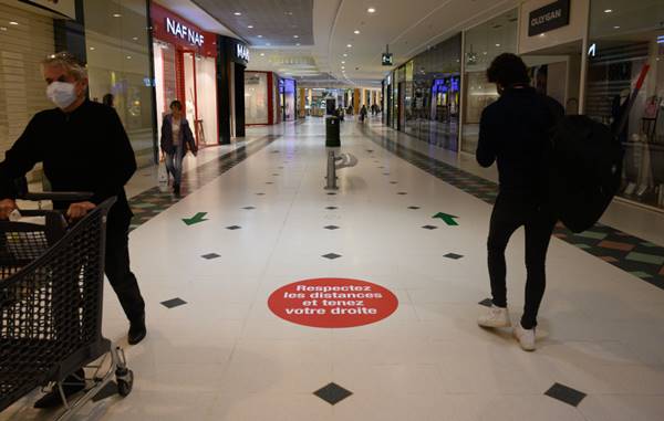 interior de shopping com setas no chão para evitar aglomeração