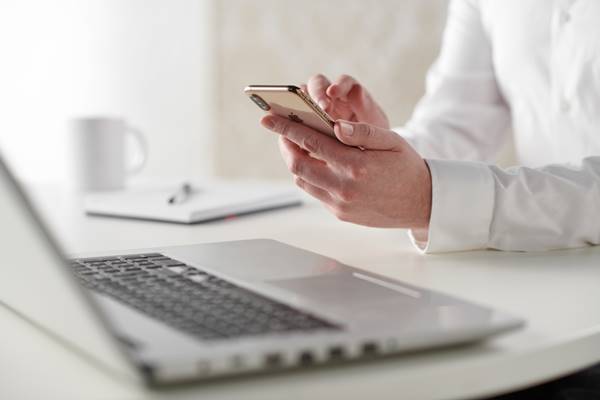 pessoa trabalhando ou estudando com celular e computador