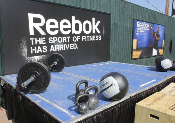 Equipamentos para prática de Crossfit com logo da Reebok ao fundo