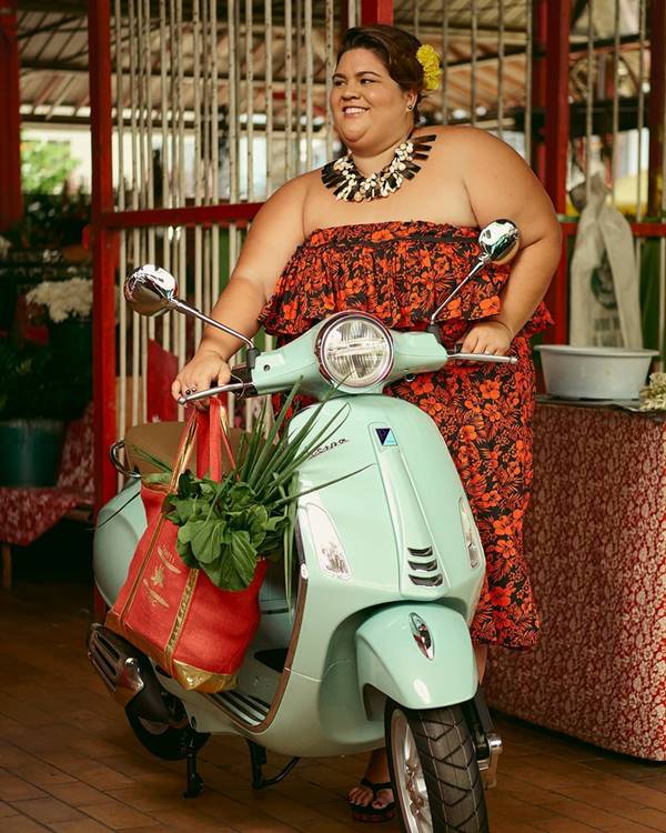 Mulher posando com uma Vespa