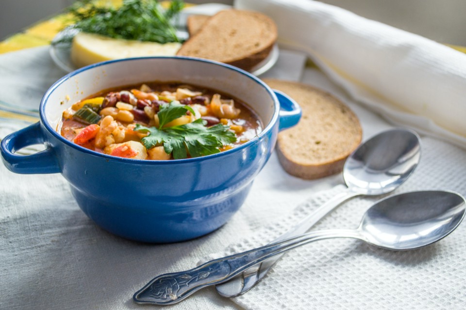 Sopa de legumes e feijão branco, bowl de sopa com colheres e torradas