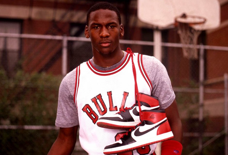 Michael Jordan posando com o primeiro modelo do Nike Air Jordan, nos anos 1980