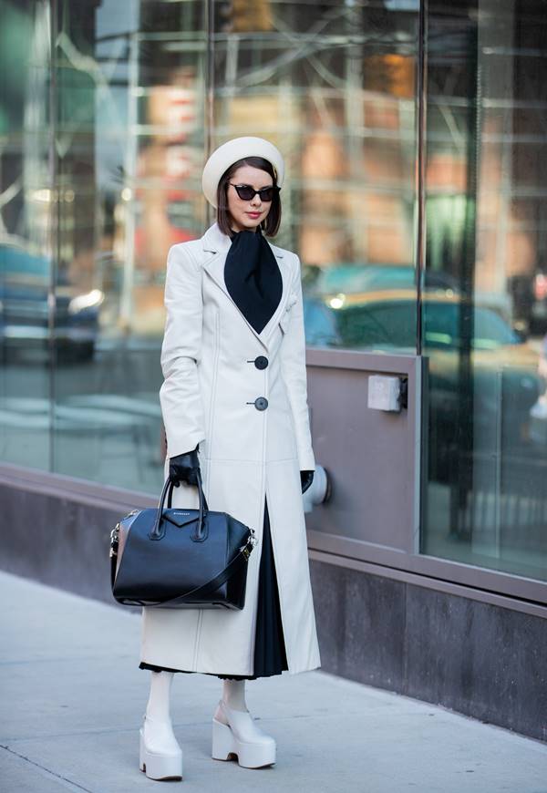 Mulher na rua com look fashionista e a bolsa Antigona, da Givenchy