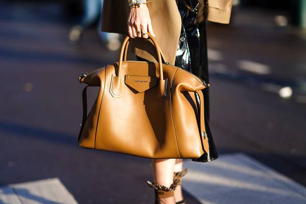 Mulher na rua com look fashionista e a bolsa Antigona, da Givenchy