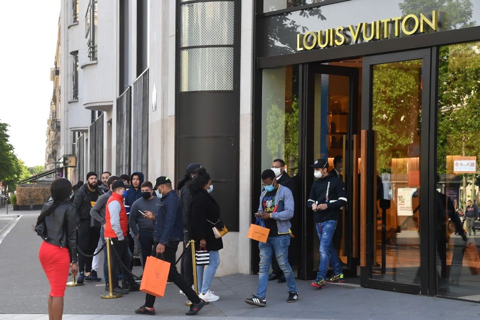 Pessoas fazendo fila em frente a loja da Louis Vuitton em Paris