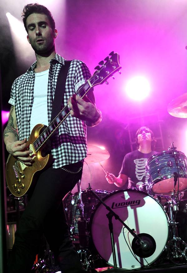 Adam Levine com camisa xadrez e camiseta branca