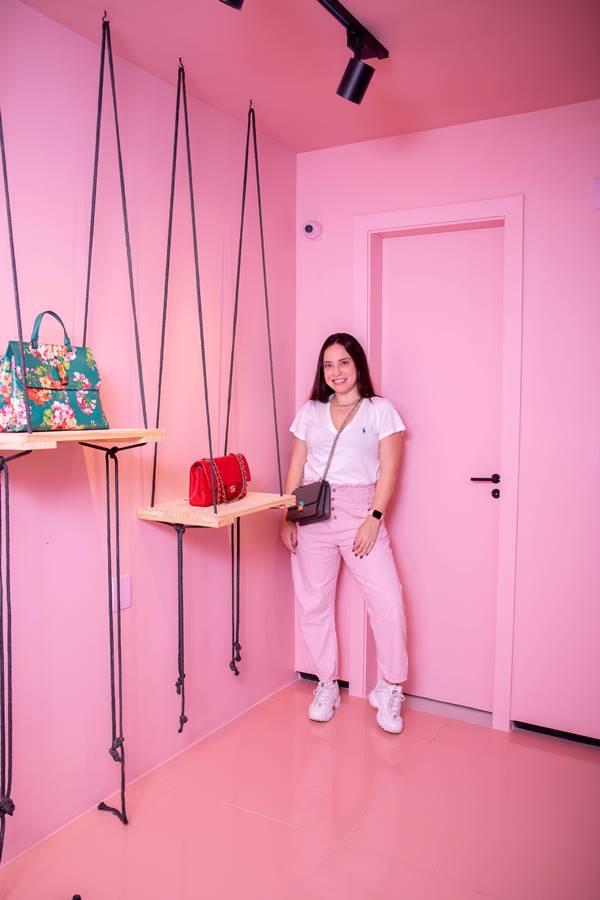 Giovanna Nardelli, da Rent Bela, em parede rosa com bolsas