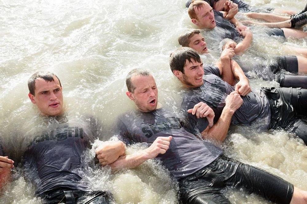 homens com braços entrelaçados no mar