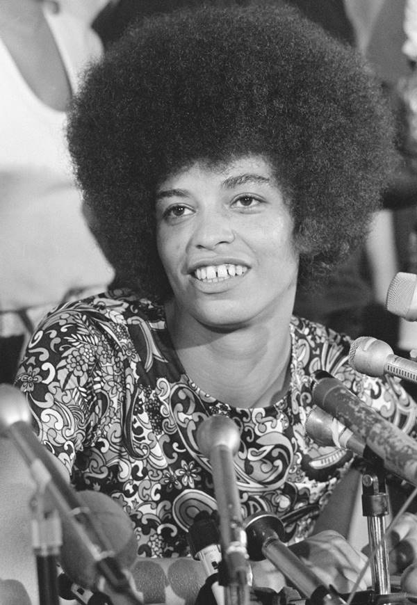 Angela Davis sorrindo em preto e branco