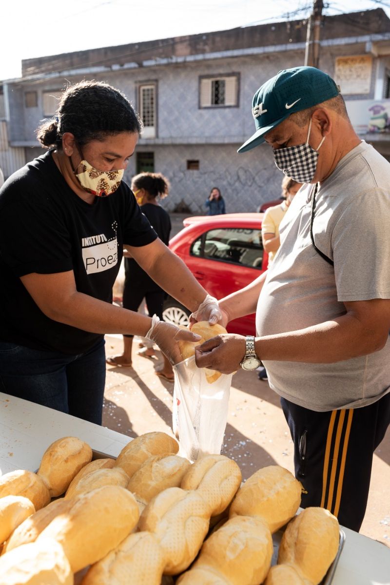 mulher entrega pães a homem