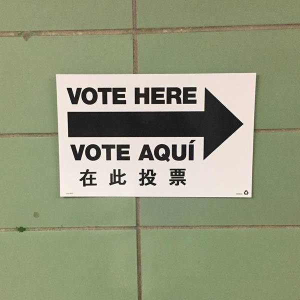 Placa com a expressão "Vote aqui" em inglês