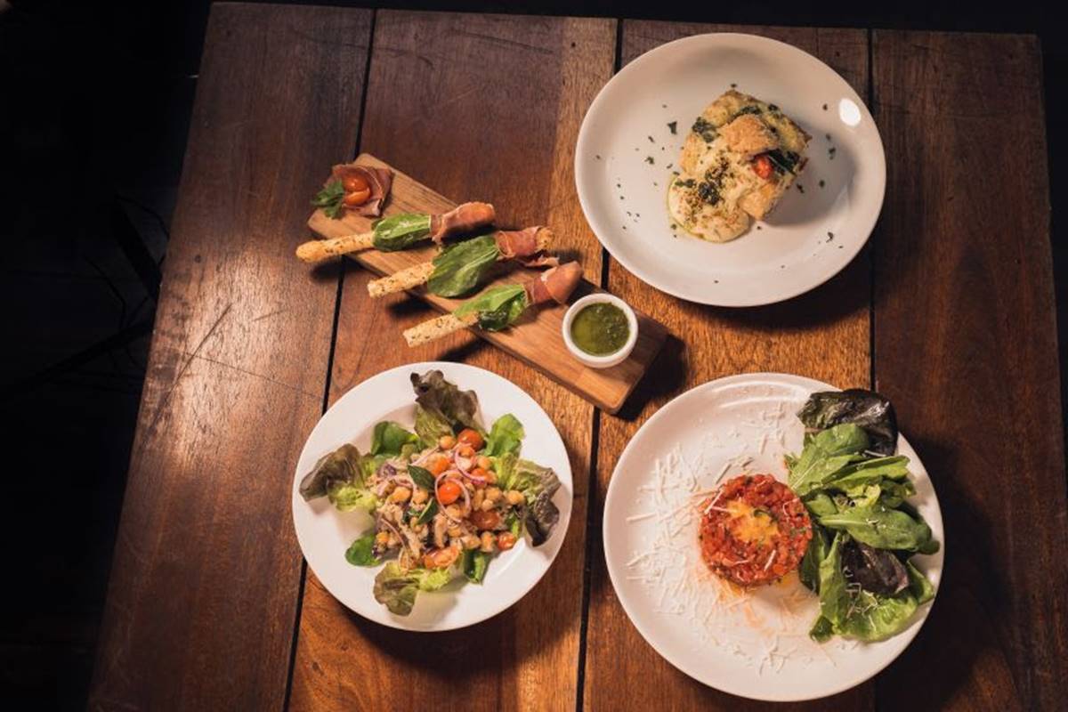 Pratos com comidas variadas sobre uma mesa de madeira