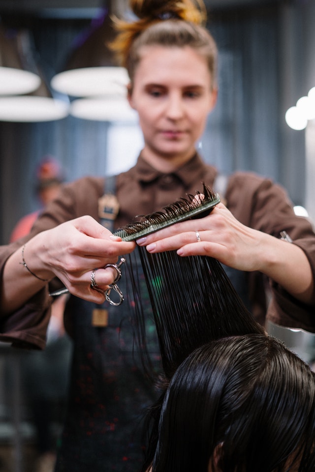 cabeleireira cortando o cabelo de mulher