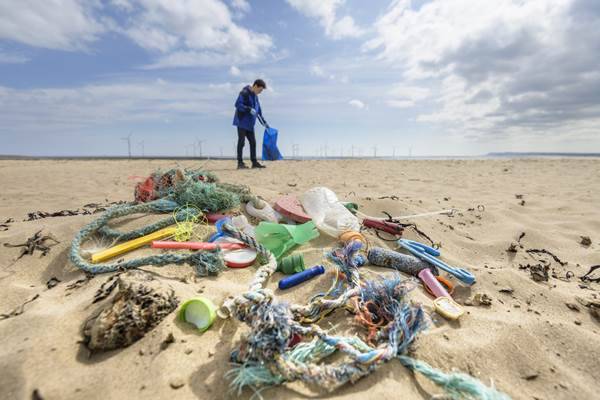 Homem em praia poluída