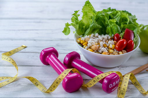 prato de salada com pesos e fita métrica