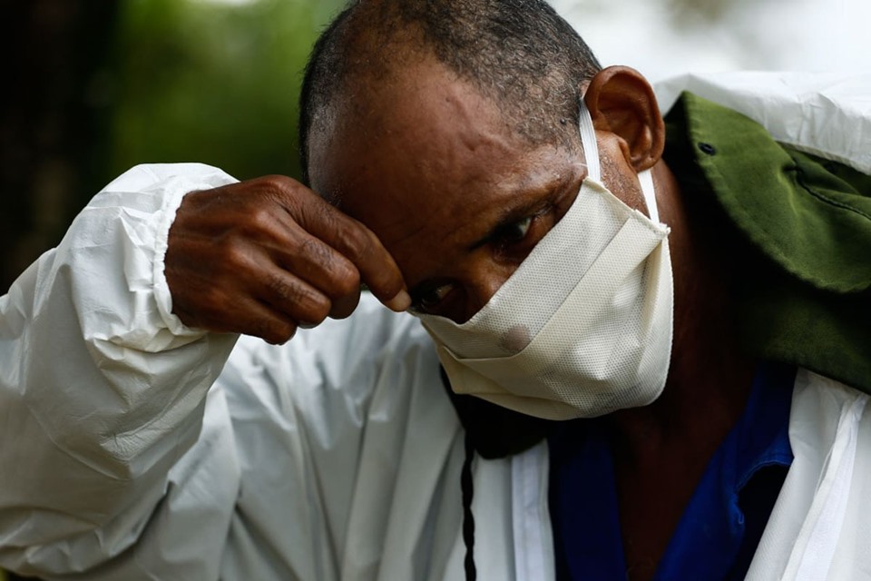 coveiros de cemitério municipal, em goiânia, goiás, enterram vítima de covid-19. rotina cansativa