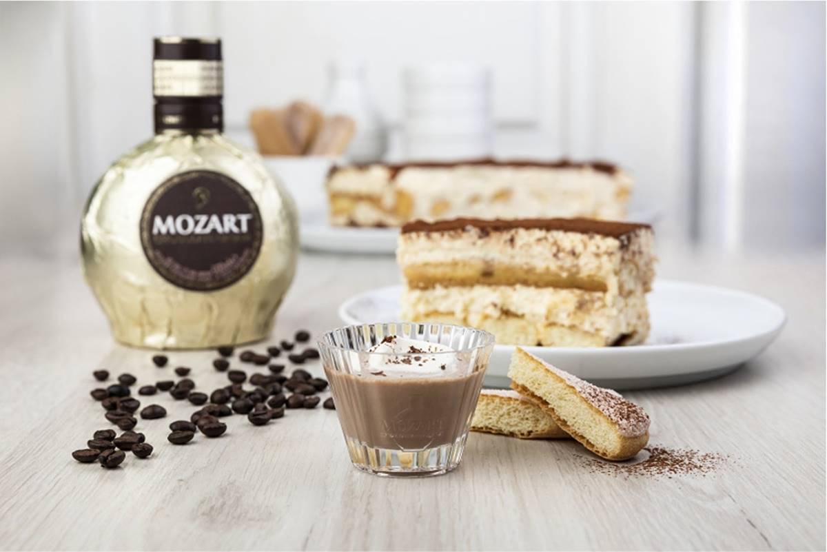 Mozart Chocolate Tiramisu com licor Mozart e pedaço de tiramisu ao fundo