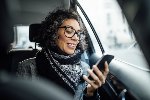 Mulher mexendo no celular no carro