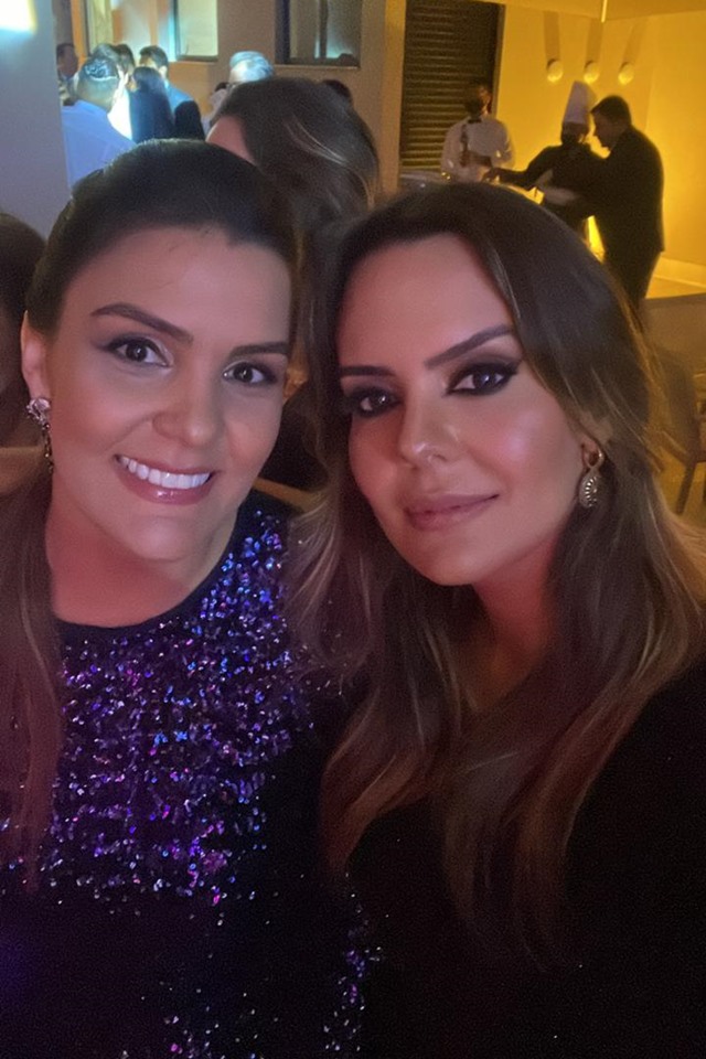 Carolina Mendes e Caroline Kalil sorriem para foto em inauguração de escritório Nelson Wilians. Ambos usam terno - Metrópoles