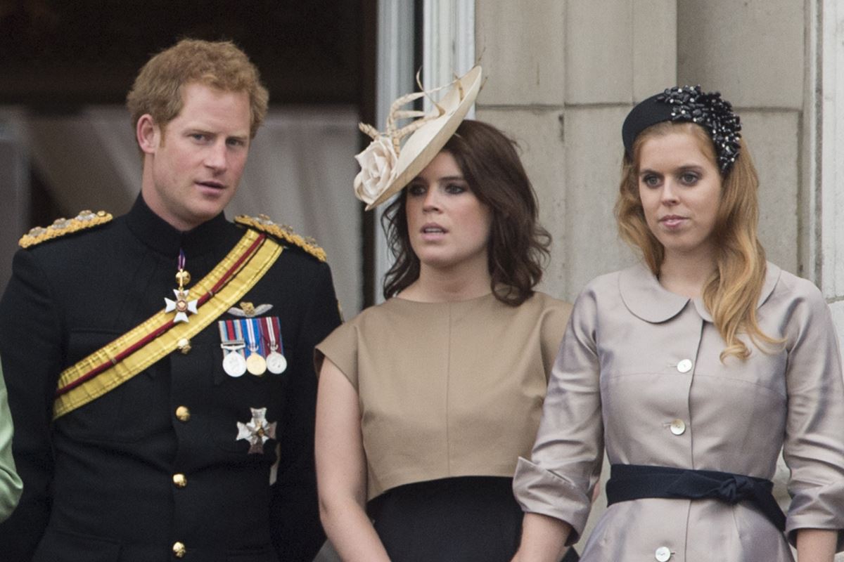 Imagem mostra o príncipe Harry com Eugenie e Beatric. Todos são brancos e usam roupas formais - Metrópoles