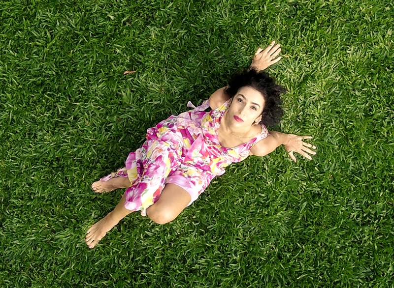 Na imagem com cor, Marisa Monte deitada na grama - Metrópoles 
