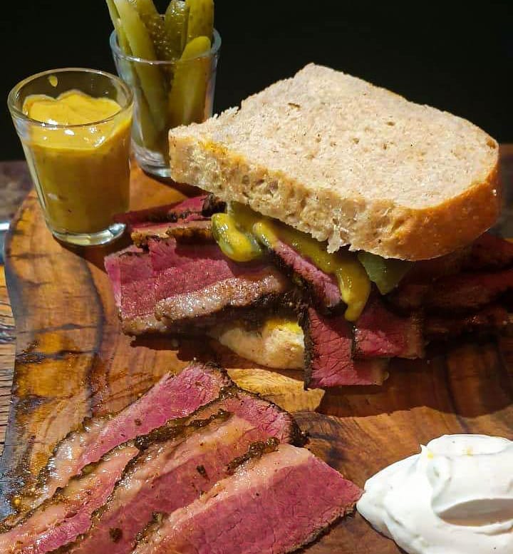 Foto colorida de um sanduíche de pastrami - Metropoles