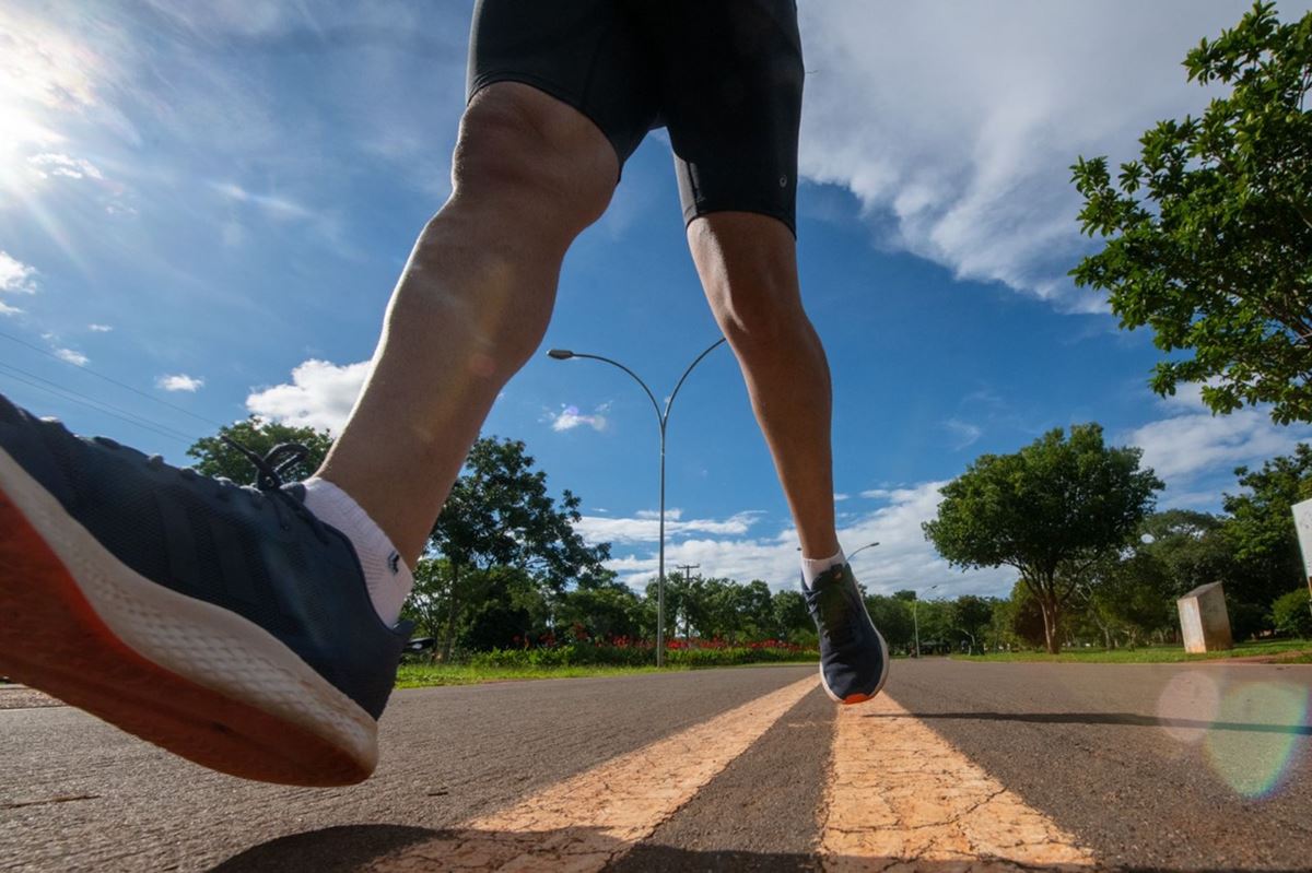 Pernas de atleta correndo na pista