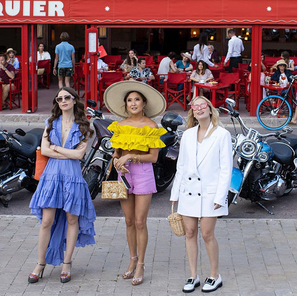 Três mulheres olhando para o alto em cena da série Emily in Paris