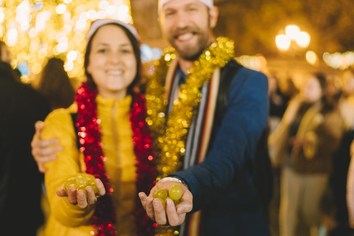 Casal abraçado com uvas na mão