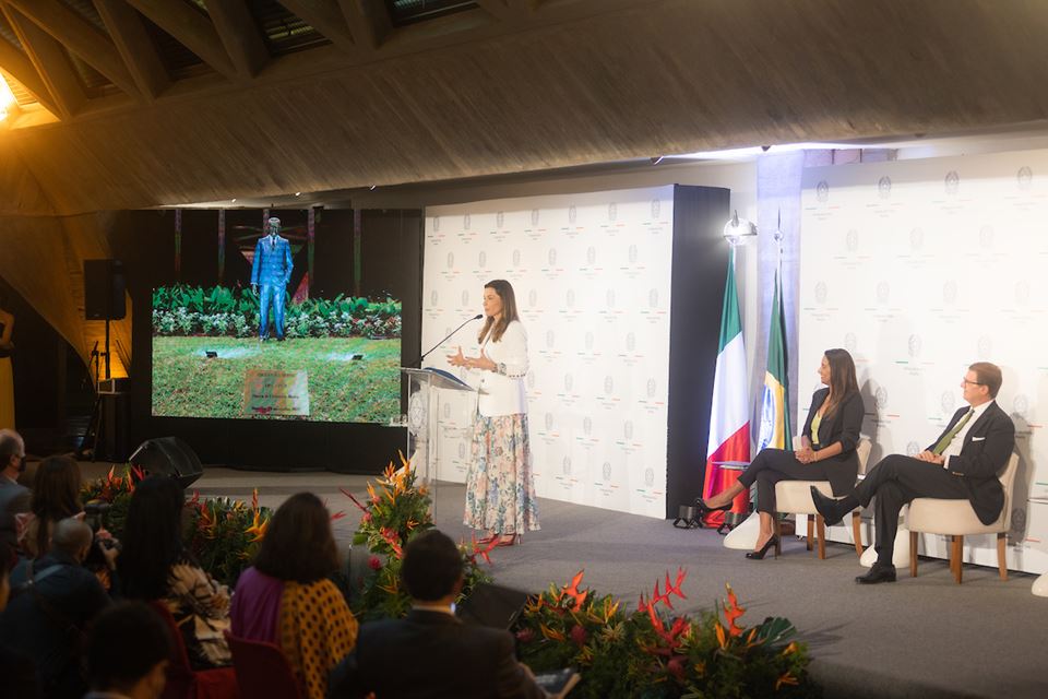 Mulher no palco falando ao microfone