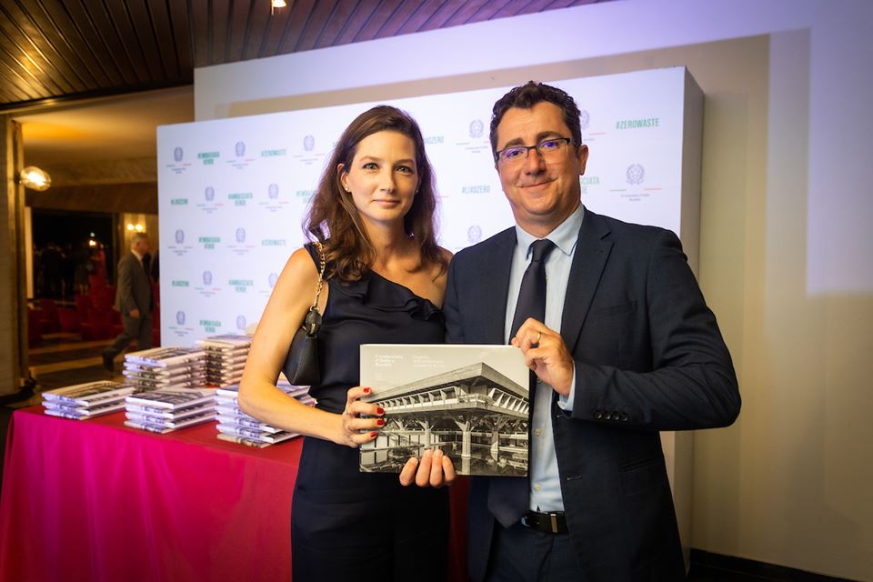 Mulher e homem posam para a foto segurando um livro