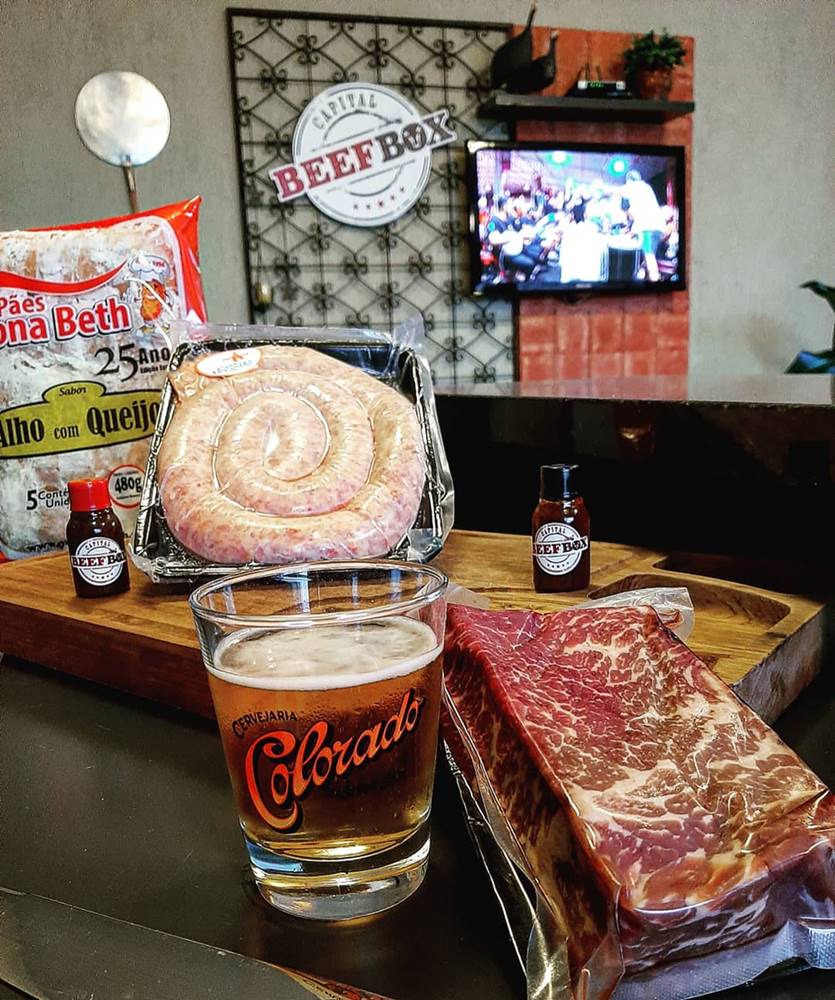 Na foto,, várias carnes ensacadas e cerveja em um copo