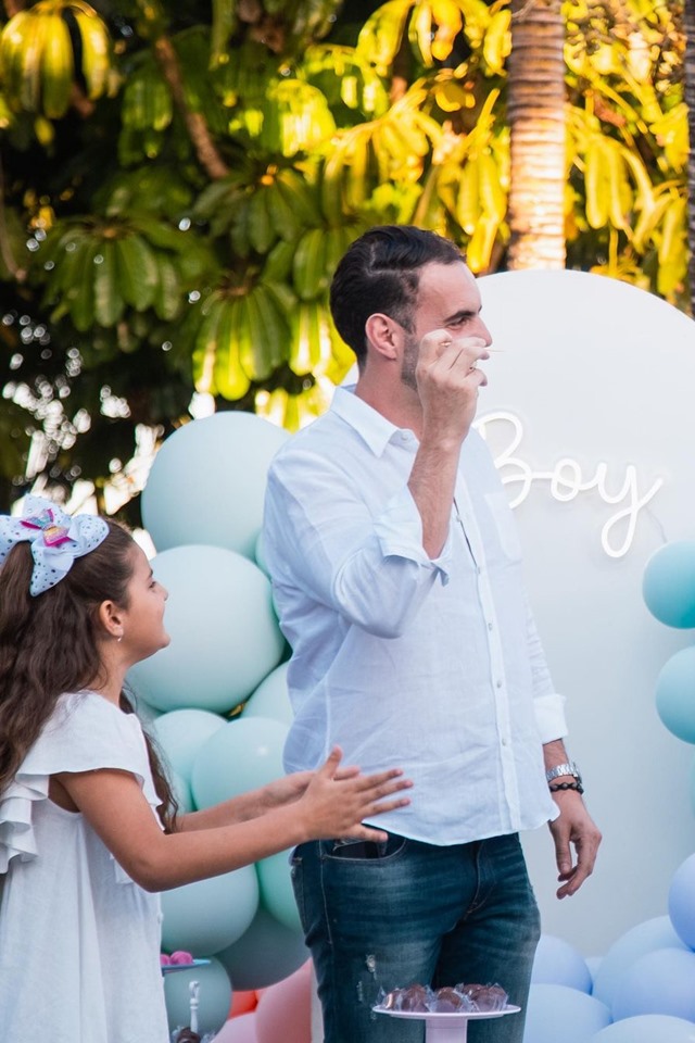 Menina ao lado de homem em uma festa com balões coloridos 