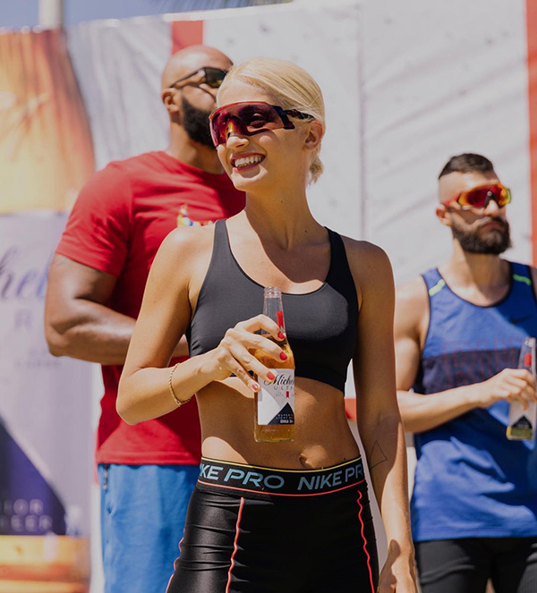 Mulher branca com roupa preta de corrida e óculos esportivos