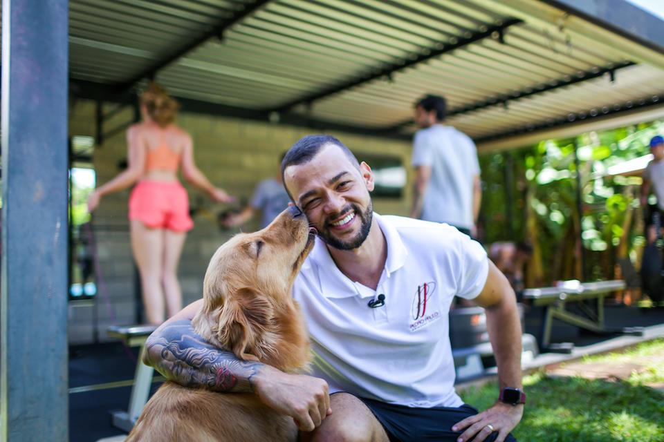 Homem abraçado com cachorro. O pet beija o rosto do homem