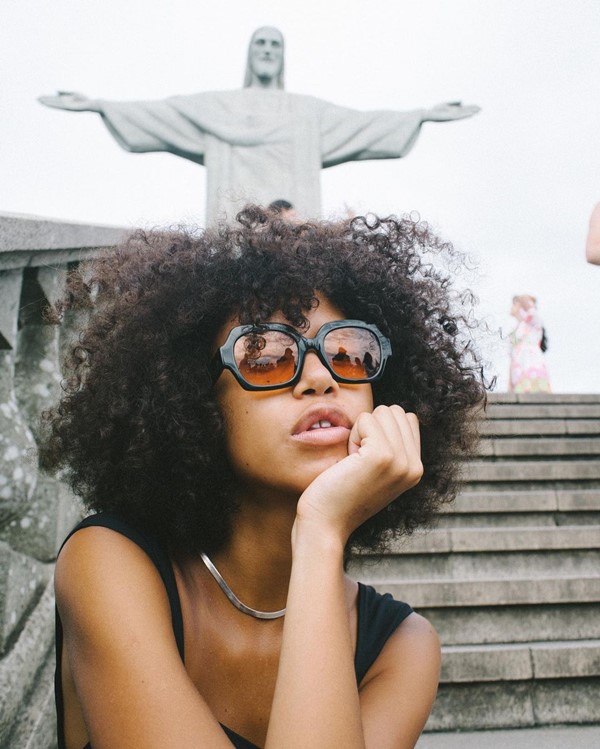 Modelo negra com óculos escuro em frente ao Cristo Redentor, no Rio de Janeiro