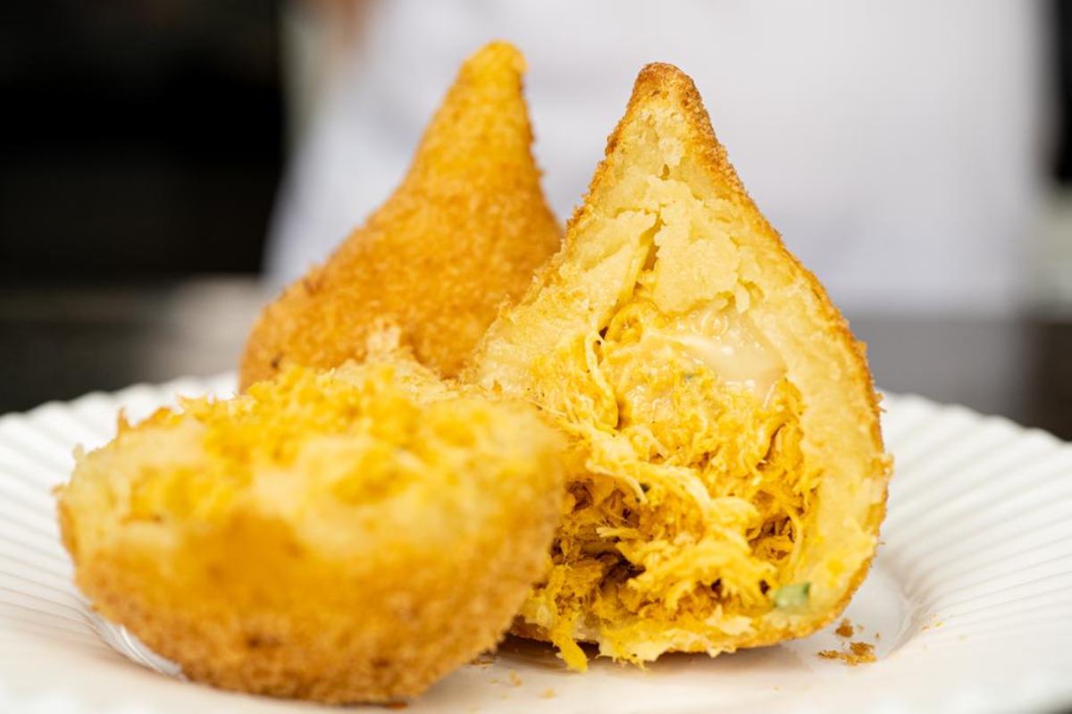 Foto de coxinha de frango partida ao meio na vertical