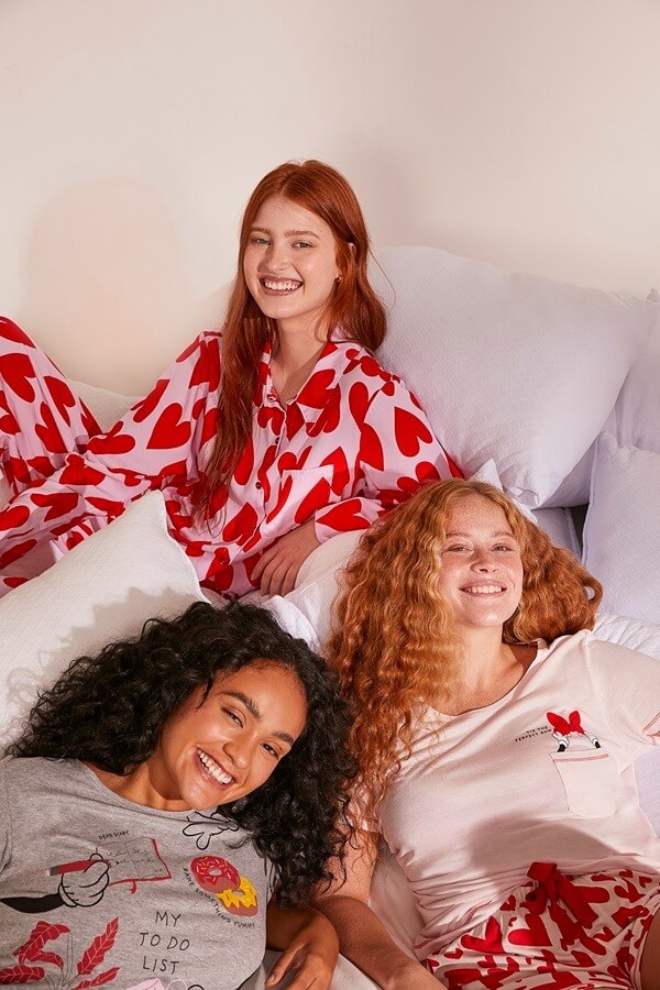 três meninas deitadas na cama sorrindo 