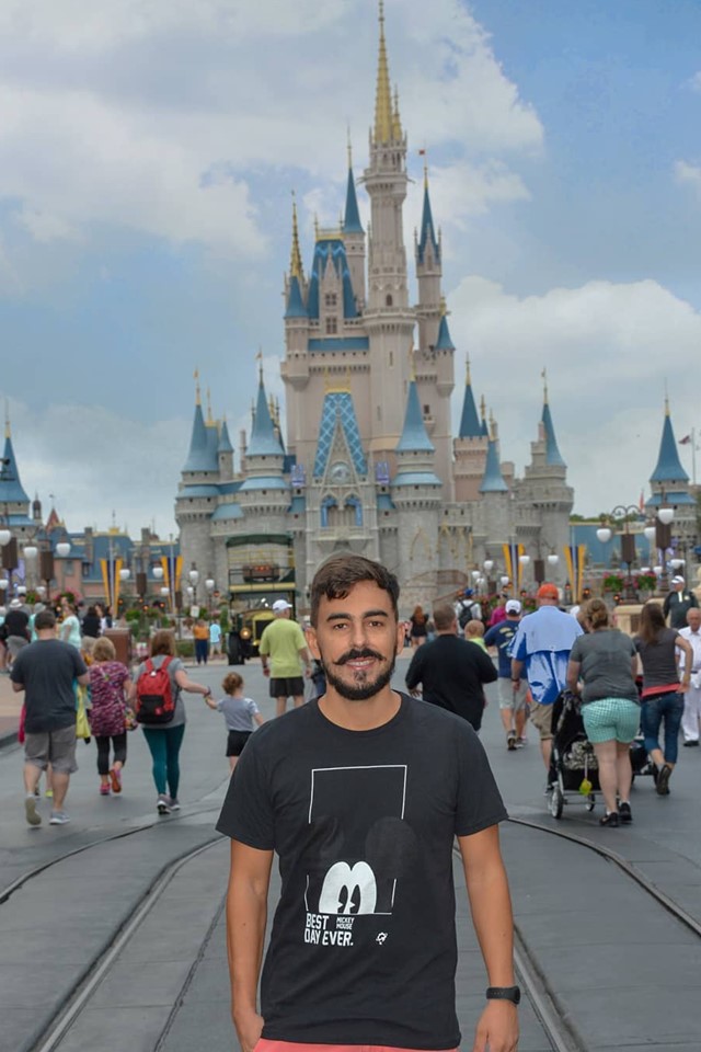 Homem na frente de um castelo rodeado por pessoas 