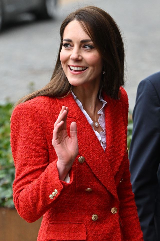 Mulher de blazer vermelho dá tchau