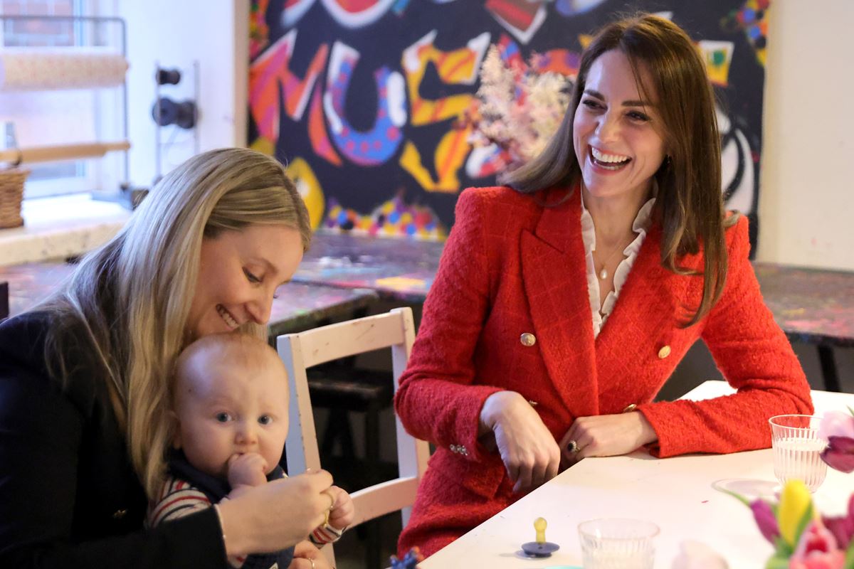 Duas mulheres sentadas conversando. Uma delas está com um bebê no colo