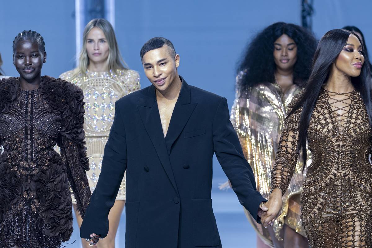 Modelos na passarela de mãos dadas com estilista