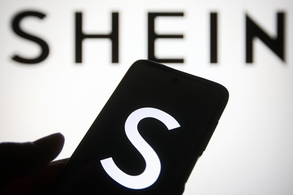 Na imagem com cor, celular com a logo da Shein - Metrópoles